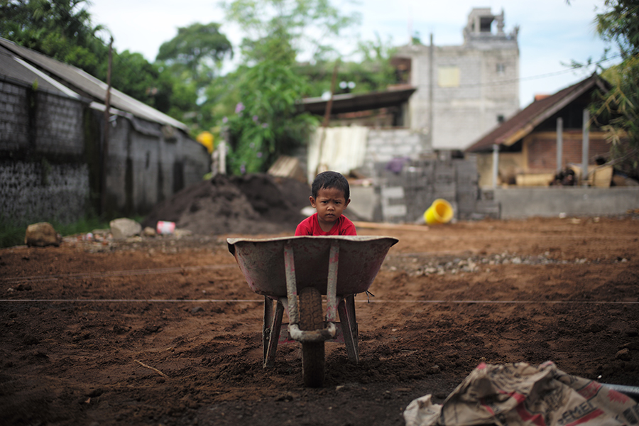 Child sitting in wheelbarrow