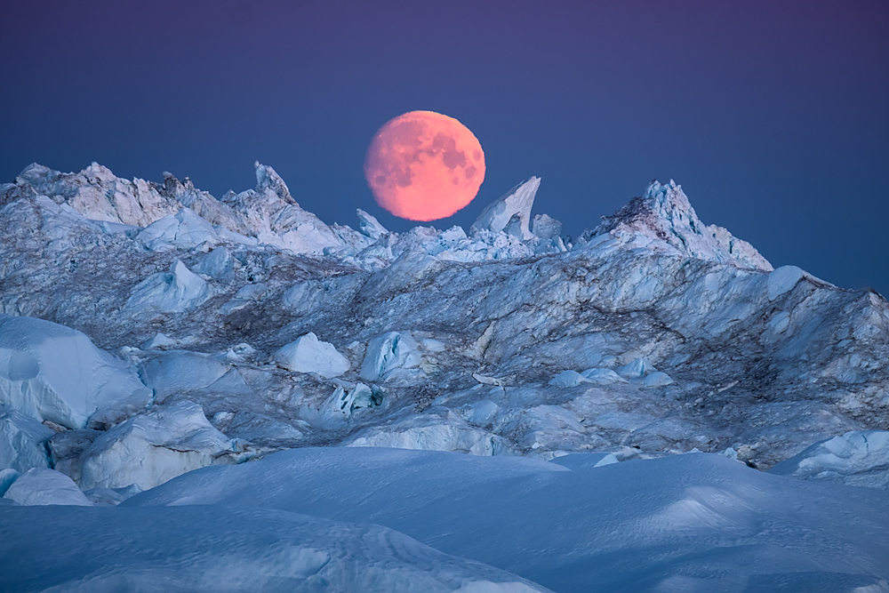Moon rising over Icebergs in Ilulissat Icefjord, Greenland